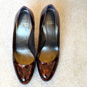 Brown and black patent Stuart Weitzman pumps.